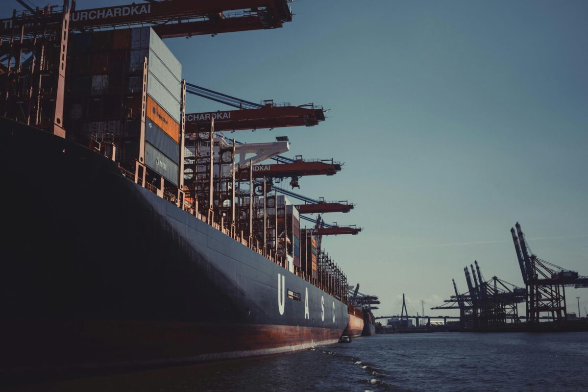 UASC cargo ship docked at port with CHARDOKAI cranes and containers on deck.